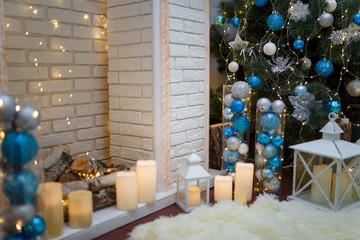Christmas and New Year living room interior with decorated firtree, blue toys, white candles, garland lights