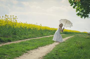 beautiful blond girl posing with white sunshade umbrella