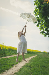 beautiful blond girl jumping with white sunshade umbrella