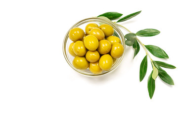 Some fresh olives in a glass bowl and olive branch on the white background.