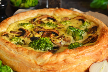 Quiche with mushrooms, onions and broccoli on a concrete background. Pie with mushrooms.