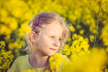 adorable charming blond girl in yellow meadow
