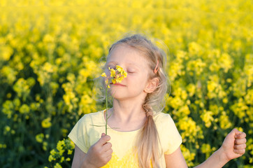 charming blond girl relaxing in yellow meadow