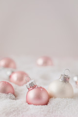 Silver and pink Christmas balls on snowy background, toned