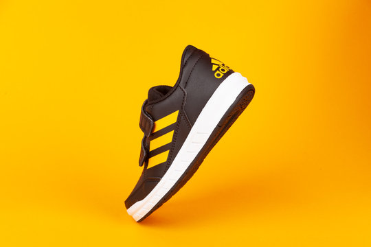 Varna , Bulgaria - AUGUST 13, 2019 : ADIDAS ALTA SPORT  shoe, on yellow background. Product shot. Adidas is a German corporation that designs and manufactures sports shoes, clothing and accessories