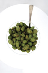 Close-up photo of a pile of wasabi seeds a glass isolated on a white background without people