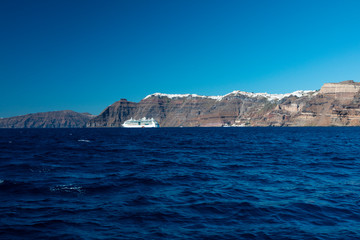 Fototapeta na wymiar A cruise ship on the blue Aegean Sea near Santorini Island in the Greek Islands