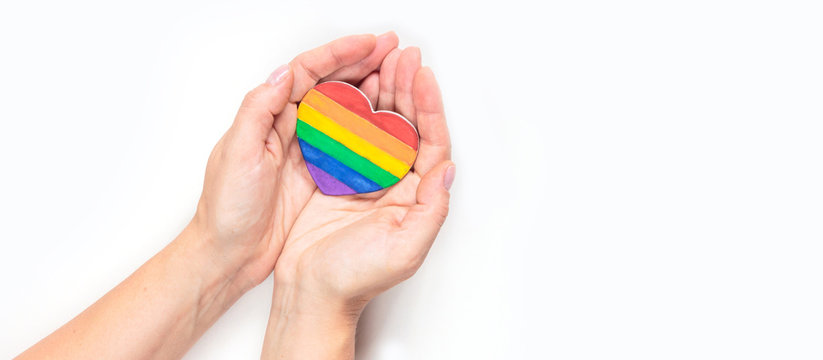 concept of gay pride, LGBT. Hand making heart sign with LGBT gay pride, heart with a rainbow flag