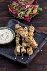 Grilled chicken skewers with hummus and salad