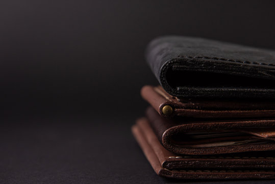 leather wallets on a black background with space for an inscription. Leather craft concept.