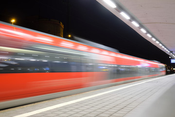 Fototapeta na wymiar Einfahrender Zug des Nahverkehrs in den Hauptbahnhof Koblenz in der Nacht - Stockfoto