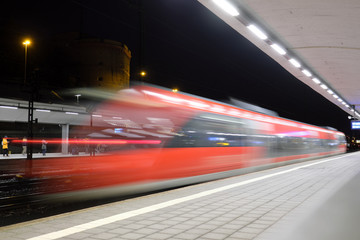 Fototapeta na wymiar Einfahrender Zug des Nahverkehrs in den Hauptbahnhof Koblenz in der Nacht - Stockfoto