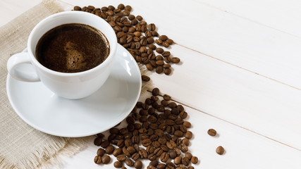 coffee cup and coffee beans on wooden table