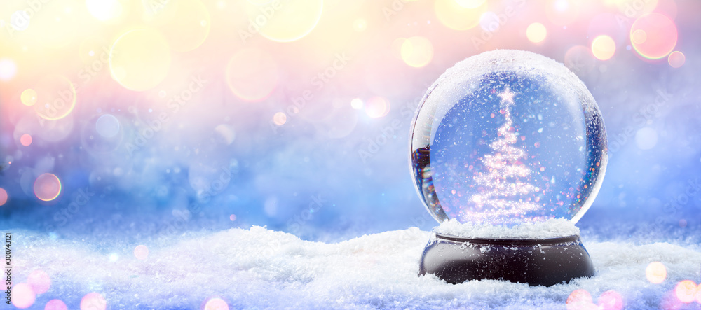 Wall mural shiny christmas tree in snow globe on snow with golden lights