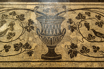 Ancient mosaic formed by an amphora with flora
