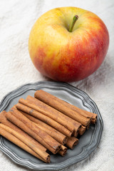 Winter pastry food ingredient, dried aromatic cinnamon sticks and apple on tin plate