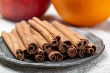 Winter food ingredient, dried aromatic cinnamon sticks on tin plate