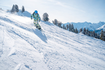 Photo of sports man in helmet with snowboard riding on snowy slope