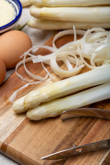 Bunch of fresh uncooked white asparagus and peeler knife, how to peel asparagus vegetables
