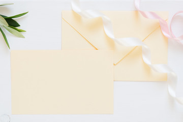 blank cream-colored envelope with ribbons, mock up for romantic invitations, wedding design