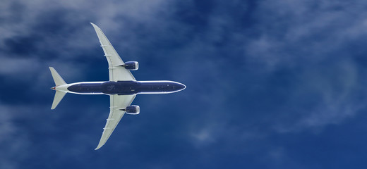 Commercial passenger jet airplane flying at the blue sky