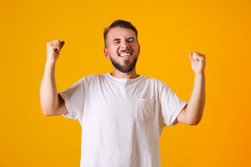 Fototapeta premium Young handsome man with facial hair posing yellow gray wall with a lot of copy space for text. Portrait of confident bearded male, wearing blank white oversized t-shirt. Isolated, background.