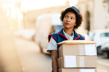 African American courier making a delivery in residential district.