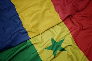 Fototapeta na wymiar waving colorful flag of senegal and national flag of romania.