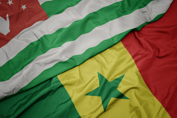 waving colorful flag of senegal and national flag of abkhazia.