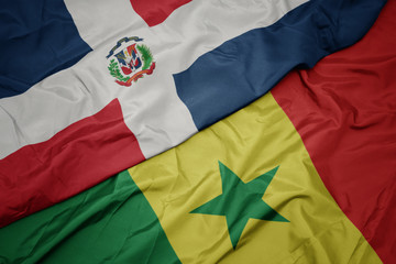waving colorful flag of senegal and national flag of dominican republic.