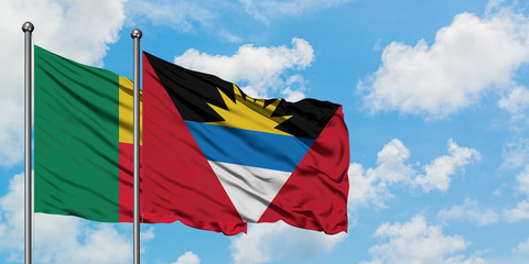 Benin and Antigua and Barbuda flag waving in the wind against white cloudy blue sky together. Diplomacy concept, international relations.