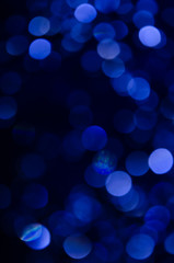 Abstract pattern of blue bokeh garland lights on a dark background