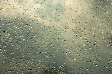 Beautiful sky and clouds, rain, wet glass, drops of water on the glass, drops of water on the window, drops