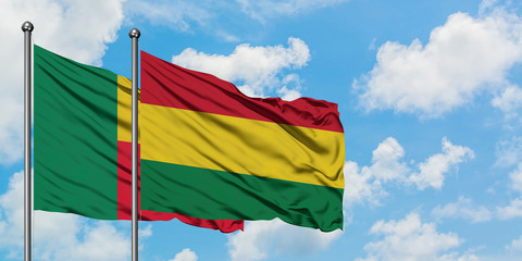 Benin and Bolivia flag waving in the wind against white cloudy blue sky together. Diplomacy concept, international relations.