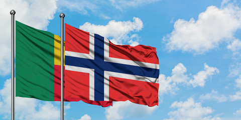 Benin and Bouvet Islands flag waving in the wind against white cloudy blue sky together. Diplomacy concept, international relations.