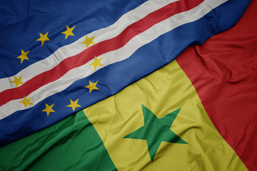 waving colorful flag of senegal and national flag of cape verde.