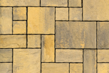 Paving slabs, stones of rectangular and square shapes of different colors laid out with patterns for equipping paths in the country as a background or texture