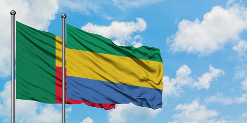 Benin and Gabon flag waving in the wind against white cloudy blue sky together. Diplomacy concept, international relations.