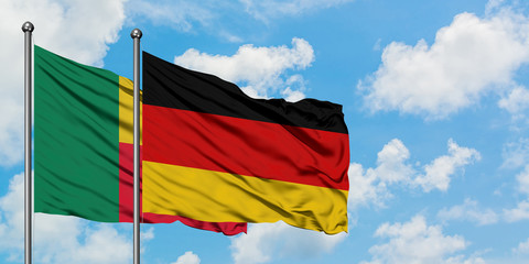 Benin and Germany flag waving in the wind against white cloudy blue sky together. Diplomacy concept, international relations.