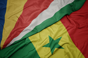 waving colorful flag of senegal and national flag of seychelles.