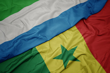 waving colorful flag of senegal and national flag of sierra leone.
