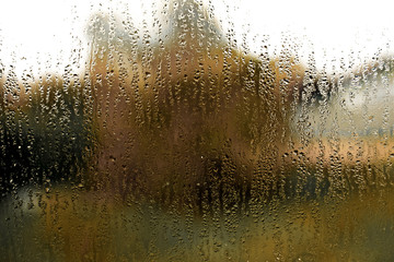 Orange tectured glass surface. Structure of water drop tracks on glazing plastic (pvc) window. Grunge pattern for texture background. Condensation drip due to bad ventilation inside house.