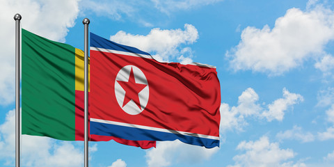 Benin and North Korea flag waving in the wind against white cloudy blue sky together. Diplomacy concept, international relations.