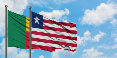 Benin and Liberia flag waving in the wind against white cloudy blue sky together. Diplomacy concept, international relations.