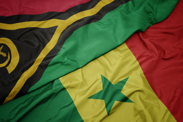 waving colorful flag of senegal and national flag of Vanuatu .