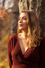 Young female model in the forest. Autumn with worm lights