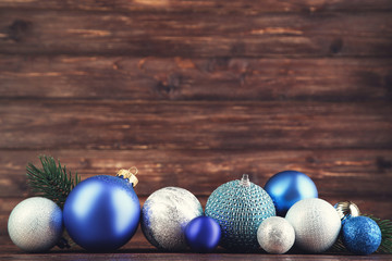 Christmas balls with fir tree branches on brown wooden table