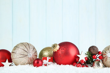 Christmas balls with gift box and red berries on wooden background