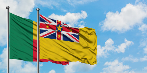 Benin and Niue flag waving in the wind against white cloudy blue sky together. Diplomacy concept, international relations.
