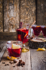 Christmas mulled wine with spices and oranges on wooden table, hot drinks